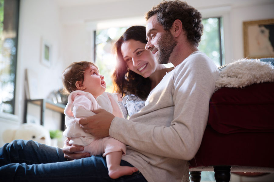 Married couple holding child in their arms