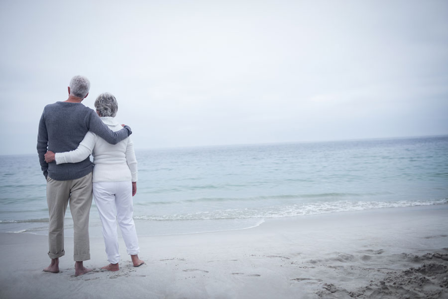 Older couple standing on a beach